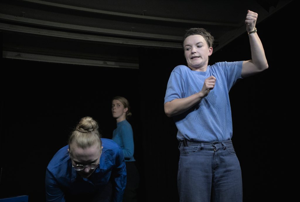 three people dressed in blue making odd movements