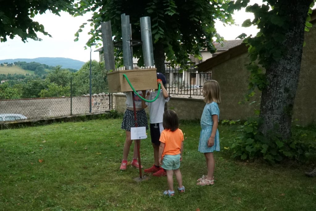 a park with a strange object and children surrounding it